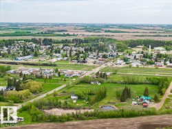 Aerial perspective highlighting a rural community surrounded by expansive agricultural fields - 