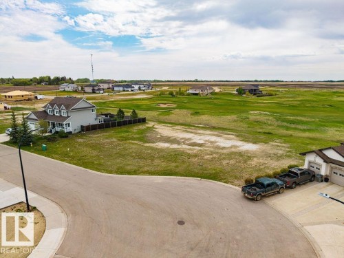 Single-family residence featuring a light gray exterior, white trim, and a prominent front porch - 25 Whitetail Green, Mundare, AB 