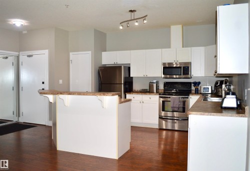 Kitchen featuring white cabinetry and light-colored countertops - 104 4312 139 Avenue, Edmonton, AB 
