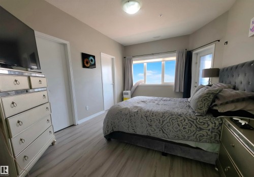 Hardwood-look flooring throughout, featuring a window and an exterior door with frosted glass - 104 4312 139 Avenue, Edmonton, AB 