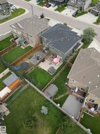 Expansive backyard featuring a green lawn, wood fencing, and a built-in deck with a pergola - 