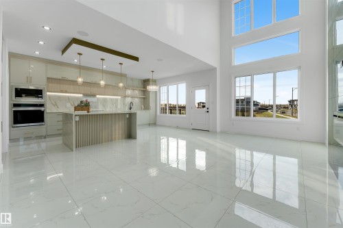 Open concept living space featuring a gourmet kitchen with built-in appliances, a large center island, and pendant lighting - 1536 64 Ave, Rural Leduc County, AB 