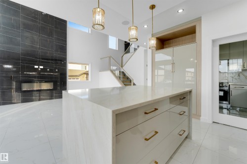 Central kitchen island featuring a waterfall countertop and integrated storage - 1536 64 Ave, Rural Leduc County, AB 