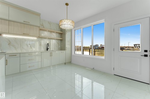 Contemporary wet bar featuring a black faucet, under-cabinet lighting, and open shelving against a marble-patterned backsplash - 1536 64 Ave, Rural Leduc County, AB 