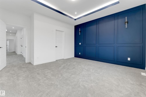 Feature wall with decorative paneling and integrated sconce lighting - 1536 64 Ave, Rural Leduc County, AB 
