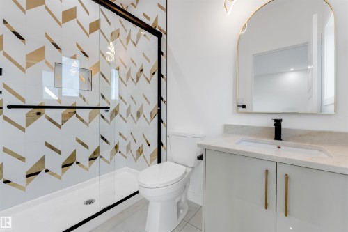 Shower enclosure featuring a custom tile surround with a geometric pattern and a black-framed glass door - 1536 64 Ave, Rural Leduc County, AB 