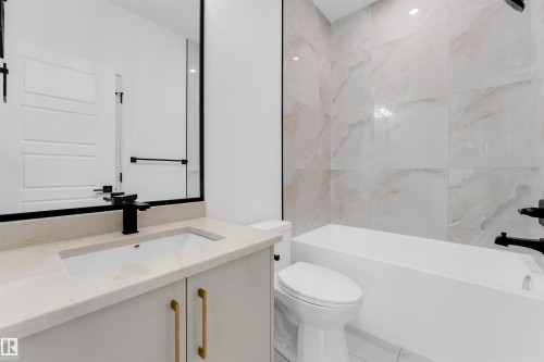 Bathroom featuring a modern vanity with light-toned countertop, built-in rectangular sink, and matte black faucet - 1536 64 Ave, Rural Leduc County, AB 