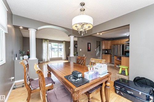 Formal dining area featuring a decorative chandelier and wood-finish flooring - 11512 24 Avenue, Edmonton, AB 