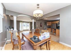 Dining area featuring a wood-finish table, chandelier lighting, and light wood-finish flooring - 