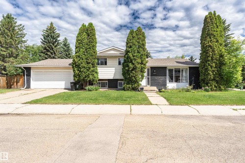 Split-level residence featuring a two-car garage with a white overhead door - 11512 24 Avenue, Edmonton, AB 