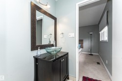 Bathroom vanity featuring a vessel sink, dark wood-finish cabinet, wall-mounted lighting, and a large framed mirror - 
