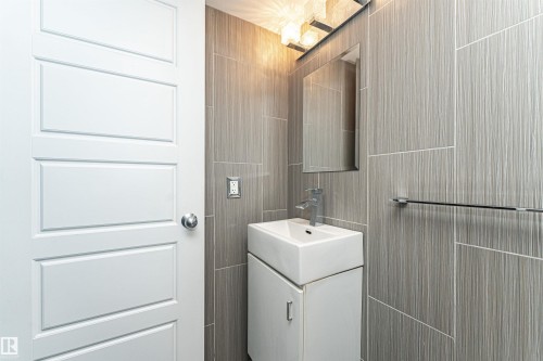 Modern bathroom with large format textured wall tiles - 11512 24 Avenue, Edmonton, AB 