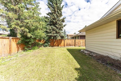 Expansive grassy lawn with a wood plank fence - 11512 24 Avenue, Edmonton, AB 