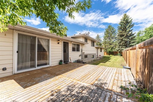 Expansive wood-plank deck with a sliding glass door entry to the property - 11512 24 Avenue, Edmonton, AB 