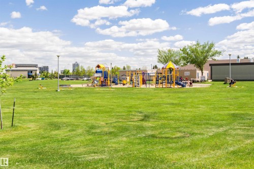 Expansive green space featuring a large playground with multiple slides and climbing structures - 11512 24 Avenue, Edmonton, AB 
