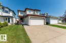 Two-story residential property featuring light-colored siding, a brown roof, and an attached two-car garage - 1816 36 Avenue, Edmonton, AB 