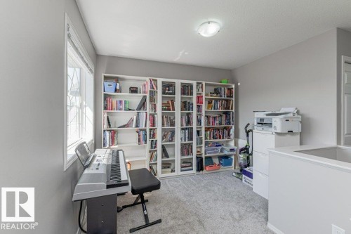 Carpeted room featuring a large window, recessed ceiling light, and built-in shelving - 1816 36 Avenue, Edmonton, AB 