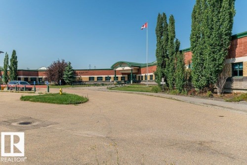 Brick exterior with green trim and a central arched entrance - 1816 36 Avenue, Edmonton, AB 