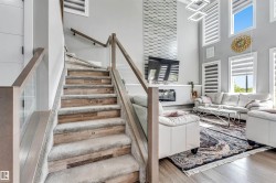 Staircase featuring wood-finish treads with carpet runners and glass railings - 