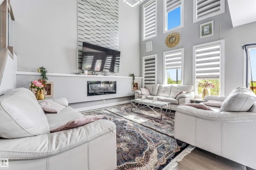 Spacious living area featuring a vaulted ceiling and an integrated fireplace - 715 Ebbers Place Nw, Edmonton, AB 