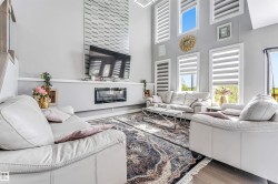 Spacious living area featuring a vaulted ceiling and an integrated fireplace - 