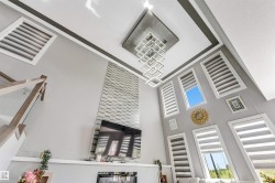 Soaring ceilings featuring a modern chandelier and extensive vertical windows - 