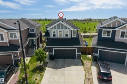 Contemporary two-story residence featuring a two-car garage, concrete driveway, and a fenced backyard - 