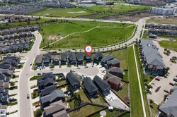 Aerial perspective showcasing a residential development with a large green space - 