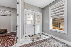 Entryway featuring double French doors with decorative glass panels, a large window with horizontal blinds, and tile flooring - 