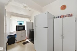 Compact kitchen area featuring white walls and light-colored flooring - 