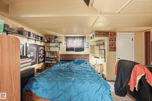 Interior space featuring a window with dark coverings, wood-finish flooring, and a white interior door - 11325 101 Street, Edmonton, AB 