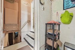 Stairwell featuring a metal handrail, painted risers, and textured wall finishes - 