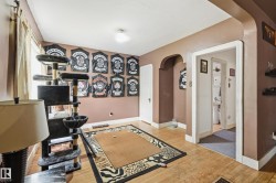 Room featuring wood-finish flooring, an arched doorway, and painted walls - 