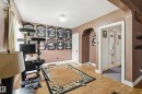 Room featuring wood-finish flooring, an arched doorway, and painted walls - 11325 101 Street, Edmonton, AB 