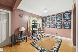 Hardwood flooring extends throughout this room, featuring a window with natural light and a white door with transom glass - 
