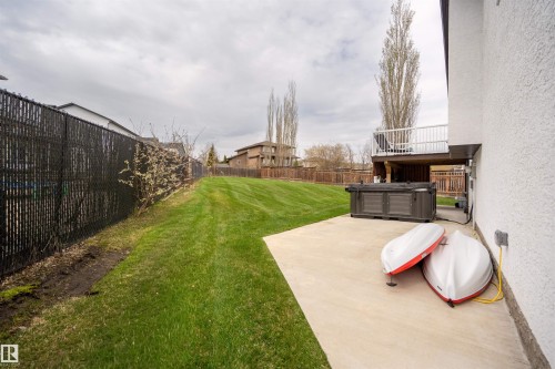 Expansive backyard featuring a manicured lawn, a large concrete patio, and a dedicated spa area - 711 Beach Avenue, Cold Lake, AB - Outdoor