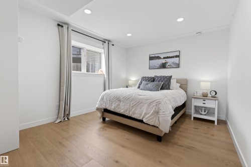 Bright bedroom featuring light wood-finish flooring, white baseboards, and a window with white trim - 711 Beach Avenue, Cold Lake, AB - Indoor Photo Showing Bedroom