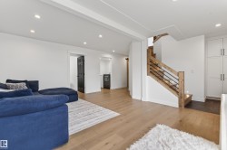 Modern staircase with light wood newel posts, handrail, and black metal balusters - 