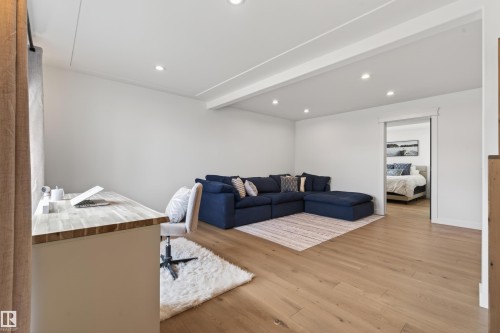 Open concept room featuring recessed ceiling lighting, light wood-finish flooring, a built-in desk with a wood butcher-block style countertop, and a doorway opening to another room - 711 Beach Avenue, Cold Lake, AB - Indoor