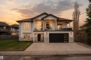 Contemporary two-story residence with a black hip roof and white stucco facade - 711 Beach Avenue, Cold Lake, AB  - Outdoor With Deck Patio Veranda 