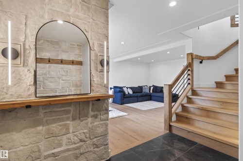 Stone veneer wall with an arched mirror and integrated lighting - 711 Beach Avenue, Cold Lake, AB - Indoor Photo Showing Other Room
