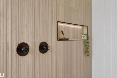 Textured paneling with integrated shower niche featuring recessed lighting and matte black fixtures - 711 Beach Avenue, Cold Lake, AB - 