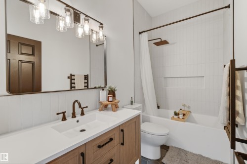 Modern bathroom featuring a single vanity with a white countertop and wood-finish cabinetry - 711 Beach Avenue, Cold Lake, AB - Indoor Photo Showing Bathroom