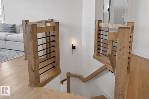 Modern staircase featuring natural wood-finish railings with black metal balusters - 711 Beach Avenue, Cold Lake, AB - Indoor Photo Showing Other Room