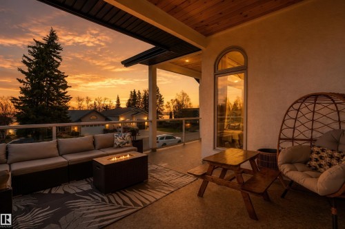 Covered balcony featuring a wood-finish ceiling, recessed lighting, arched window, and glass railing - 711 Beach Avenue, Cold Lake, AB - Outdoor With Deck Patio Veranda