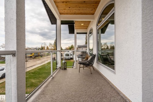 Expansive balcony featuring glass railings, wood-paneled ceiling, and recessed lighting - 711 Beach Avenue, Cold Lake, AB - Outdoor With Exterior