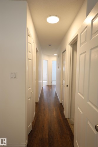 Hallway featuring wood-finish flooring, recessed lighting, and crisp white trim - 11120 132 Street, Edmonton, AB 
