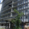 Multi-story residential building featuring a blue and white facade, individual private balconies with black metal railings, and a covered entry with steps and ramp access - 46 13435 97 Street, Edmonton, AB 