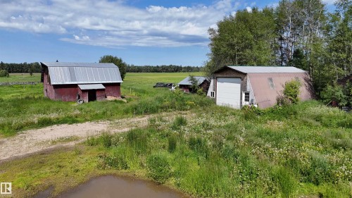 Red barn structure with a gambrel roof and an attached shed-style extension - Rural Athabasca County, AB 