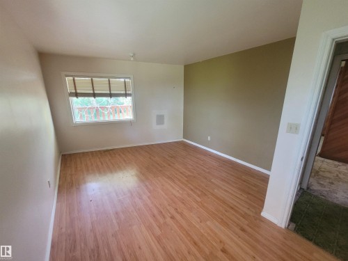 Room featuring wood-finish flooring, a neutral color palette, and a window with horizontal blinds - Rural Athabasca County, AB 